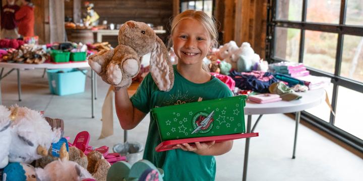 Girl smiling at a packing party holding bunny