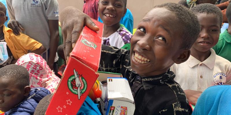 Boy grins with open shoebox gift