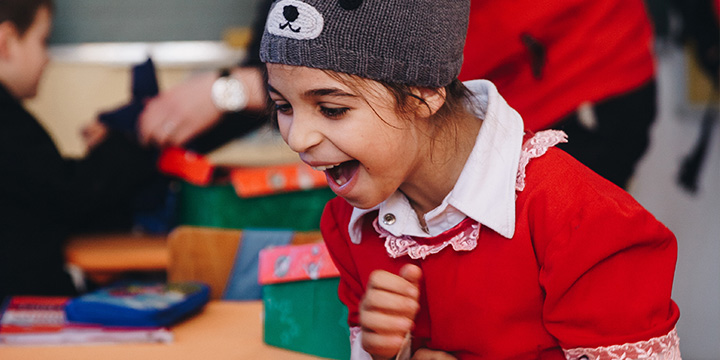 Child reacts excitedly as they open shoebox gift