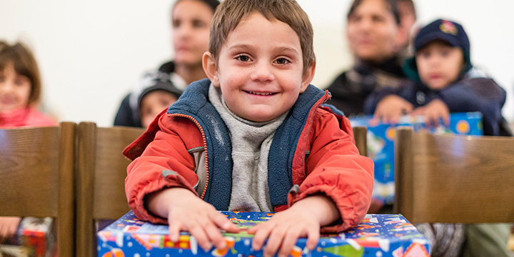 Boy smiles with blue shoebox