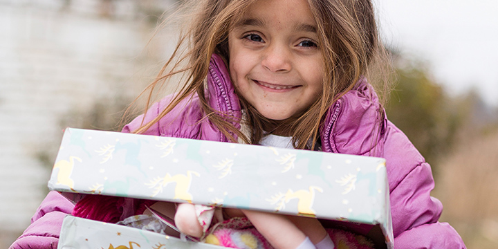 Smiling girl holding open wrapped shoebox