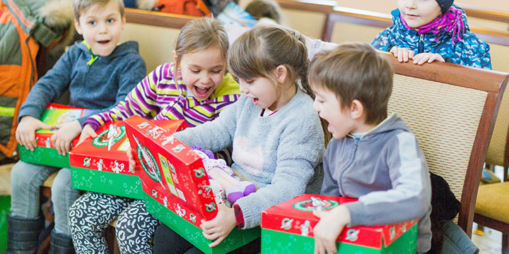 Group of children looking through shoebox gifts in Moldova