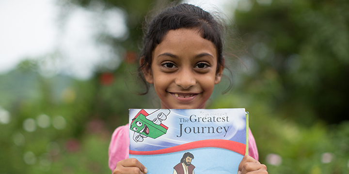Child in Fiji shows The Greatest Journey book