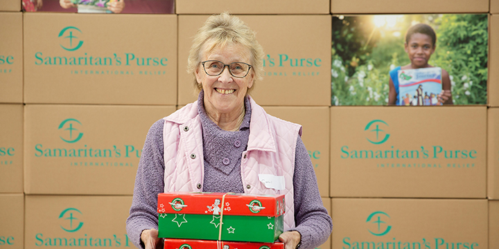 Volunteer holding shoebox gifts