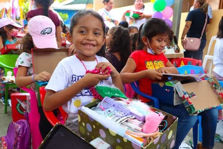 Violeta beams as she opens her shoebox gift in El Salvador.