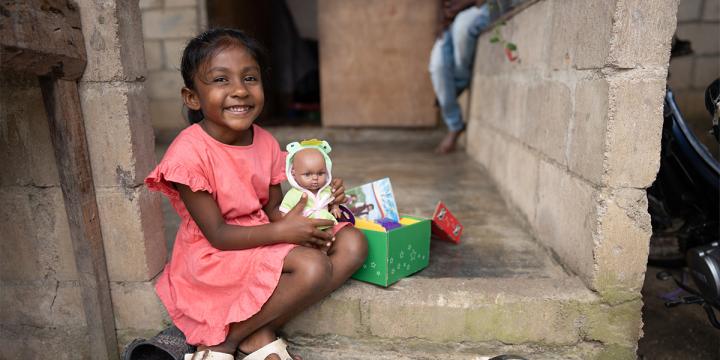 Young girl smiles and hold shoebox gift