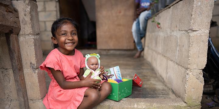 Young girl smiles and hold shoebox gift