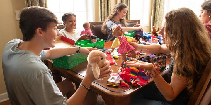 group of friends packing shoebox gifts together