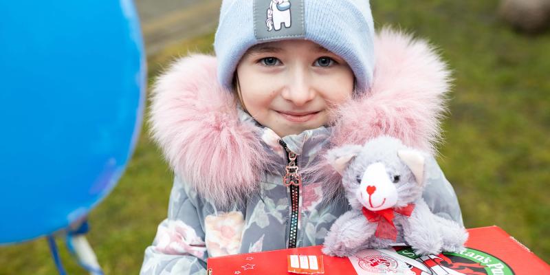 Girl smiles with new cat from shoebox gift