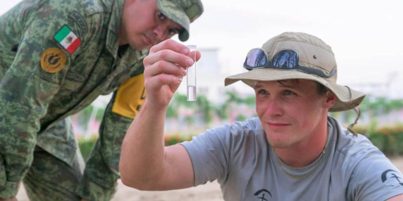 A Samaritan’s Purse staff member inspects the water produced through the desalinisation system prior to distributing it to people in need. 