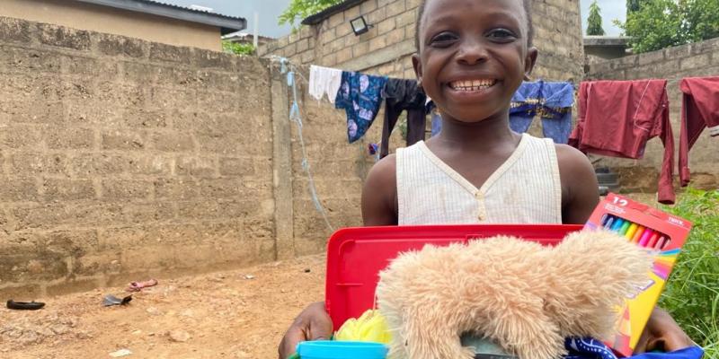 child holding shoebox with a teddy