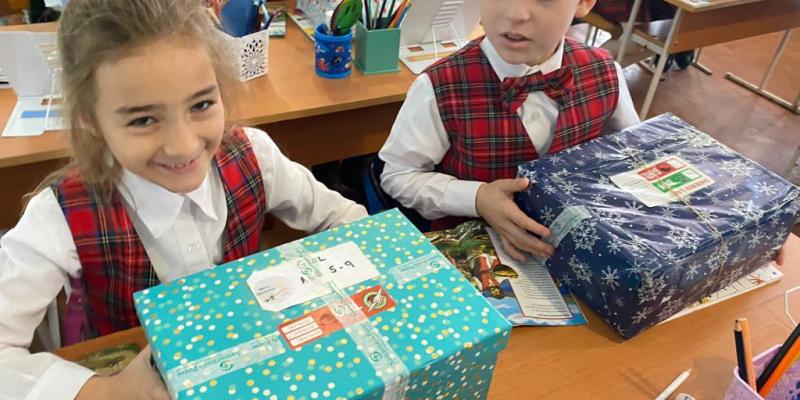 girl smiles with blue shoebox