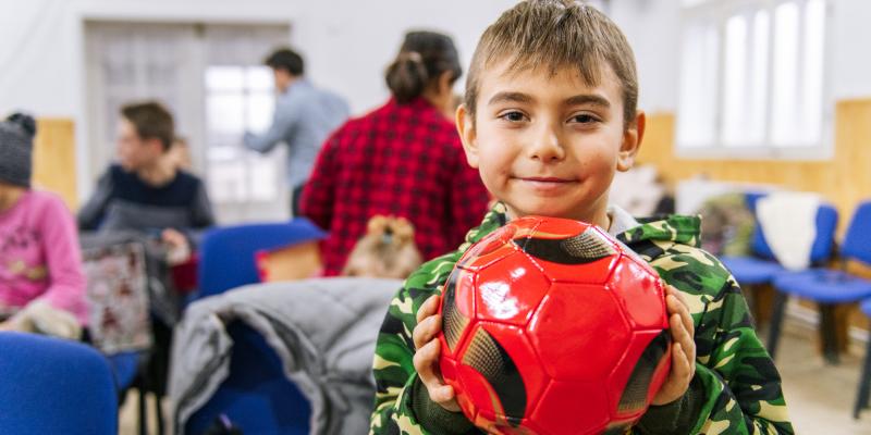 smiling boy with new red football