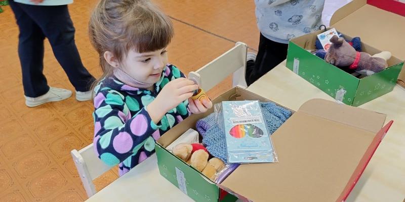 little girl exploring shoebox gift