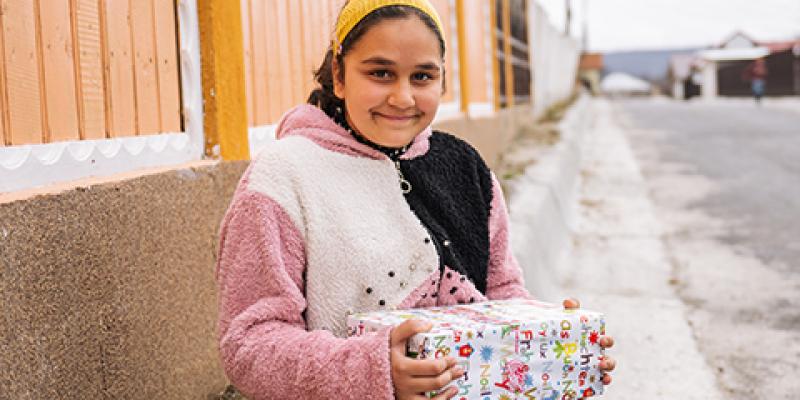 teenage girl smiling with shoebox