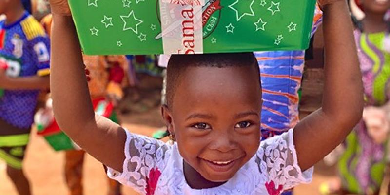 girl holds shoebox on head