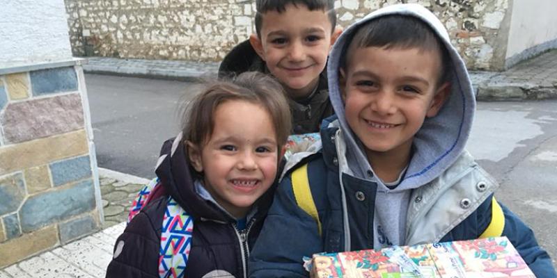 Delighted children heading home with their shoebox gifts