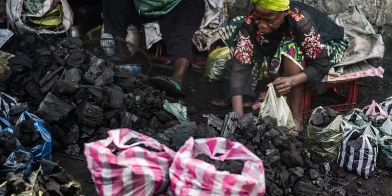 Charcoal vendors work by hand to package fuel for cooking. It’s dusty, exhausting work—but a vital income source for many women in the community.