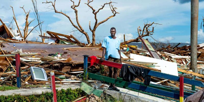 Anthony Anderson stands amid the rubble of what was once his home in Black River, Jamaica. He survived Hurricane Melissa after being trapped beneath debris for hours.