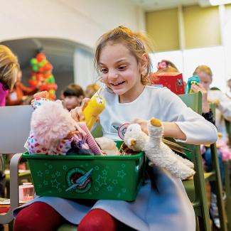 Girl with shoebox full of toys