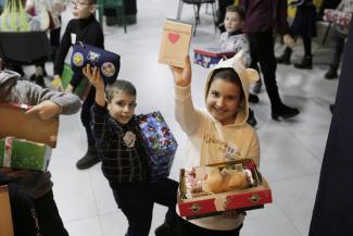 children hold up their favourite gifts