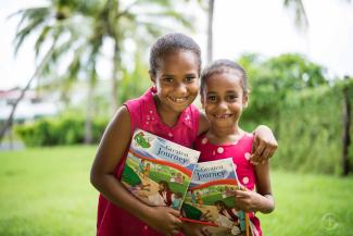 Two girls excited to receive their Greatest Journey Handouts