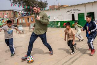 Peru: Edward Graham plays soccer with children after an outreach event.
