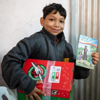 Alex with his Shoebox and The Greatest Gift Gospel booklet