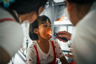 A young girl is checked out by the Emergency Field Hospital staff members.