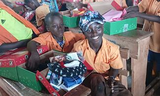 Children from the Savannah region in northern Ghana delight to open their gift-filled shoeboxes from Samaritan’s Purse. (Field photo)