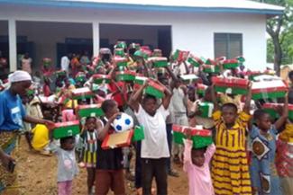 Kamara children proudly place their shoebox gifts on top of their heads after being surprised by the treasures each one held. (Field photo)