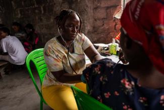 A nurse checks a patient’s blood pressure. Many residents have no access to regular health care and rely on community-based outreach for treatment.