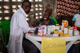 Laughter and relief are available at the dispensary table, where a pharmacist offers both medicine and kindness to patients in West Point.