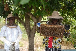 Still injured from an accident years ago, Poun (left) finds traditional labor jobs difficult for him. He is grateful for how beekeeping with Siangley helps him provide for his family.
