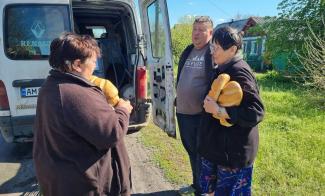 Pastor Yehven (center) delivers aid to residents in far eastern Ukraine whose traditional means of getting basics such as water and bread has been disrupted by the war.