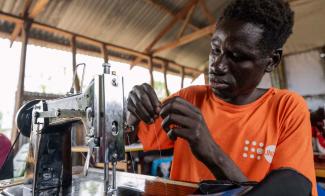 Timothy is eager to return to his village as a tailor. This new trade skill allows him to settle his family and represents a movement toward a foundation of peace in his country.