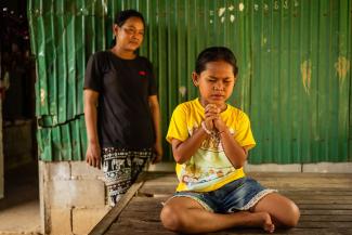 As her mother watches, Tola prays to the Lord Jesus Christ, asking Him to lead her parents to Himself, the only Saviour of the world.