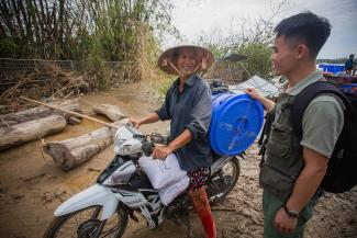 Overjoyed, Tuyen returns home with a bundle of Samaritan’s Purse relief supplies piled on her motorcycle.