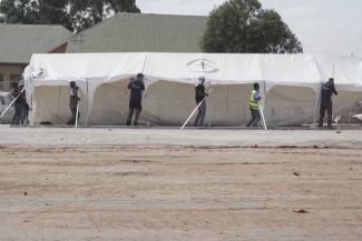 Workers raise a structure at one of our Ebola Treatment Centres under construction in Ituri Province.
