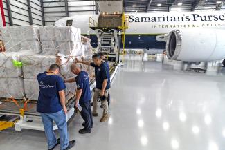 Team members pray over relief items that were later airlifted to Venezuela.