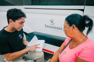Samaritan’s Purse staff shows Liliana her new Bible. Each patient goes home with a copy of God’s Word after their first consultation at our treatment centres.