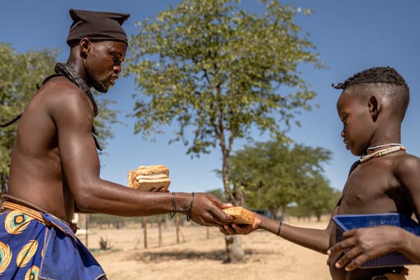 Kuyeua handing out sandwiches to the children in his village